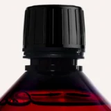 Essential Parfums Bois Impérial detergente 1L, detalle del tapón y del líquido ámbar, colada perfumada amaderada