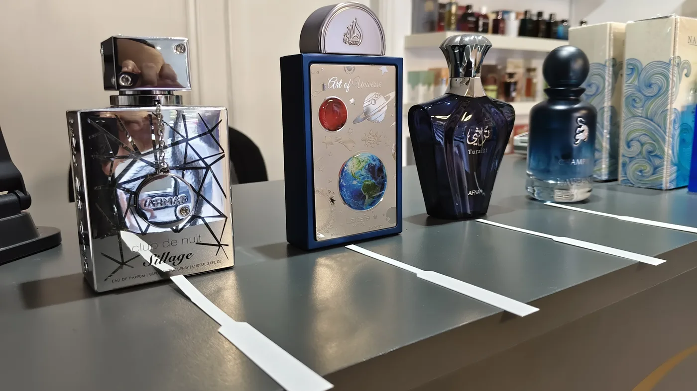Degustación guiada de perfumes árabes vista desde el lado del cliente, con Club de Nuit Sillage, Art of Universe y Turathi Blue sobre el mostrador